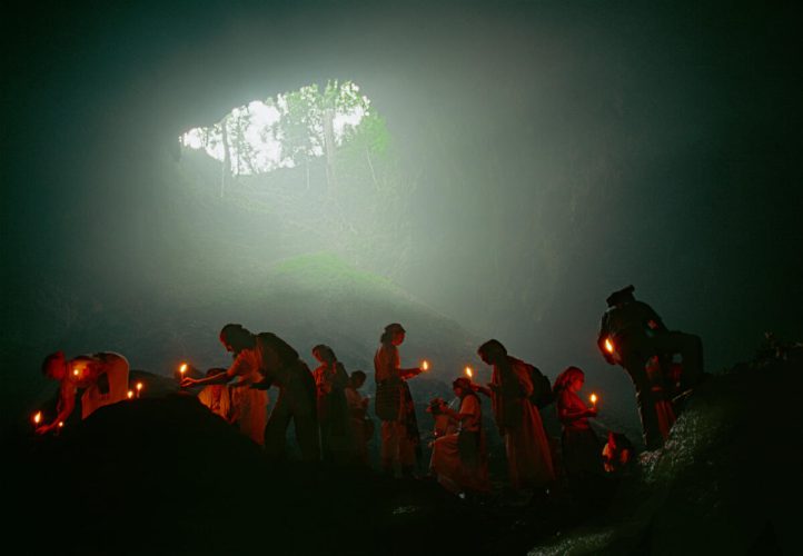 GUATEMALA. Maya Ceremony in a cave at Chicoy, near Coban. Maestro Cirilo and disciples lighting candles in observance of the Maya New Year. 1997.